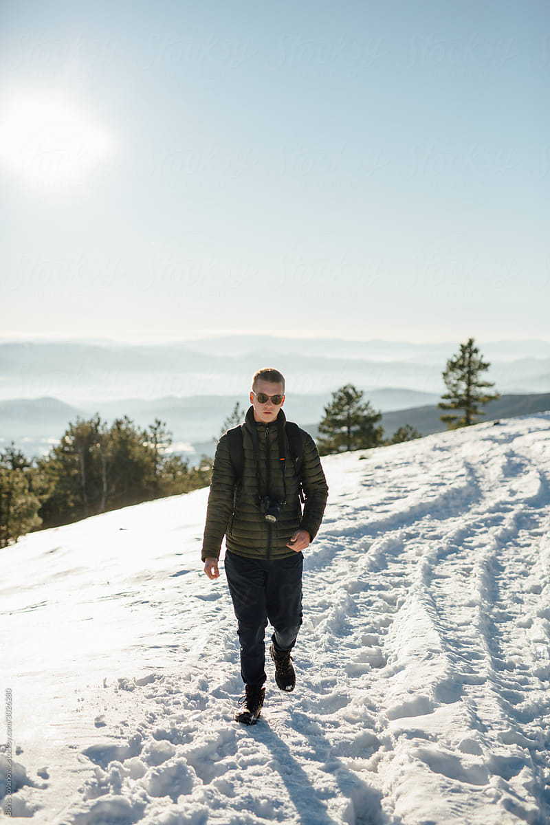 Young Man Walking On A Snowy Mountain