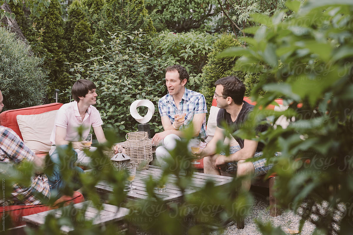Group of Gay Men Friends Having Spring Drinks Party in a Home Backyard Garden