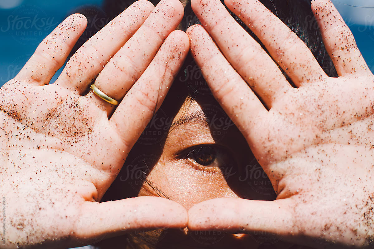 Woman\'s eye looking through hand sign in triangle shape