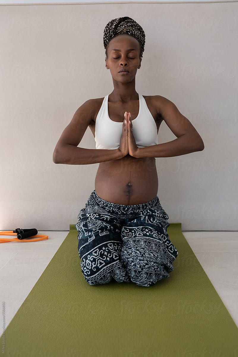 Black pregnant lady meditating in Diamond pose