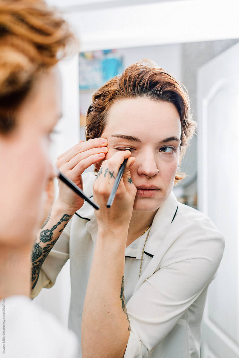 Woman applying facial cosmetics