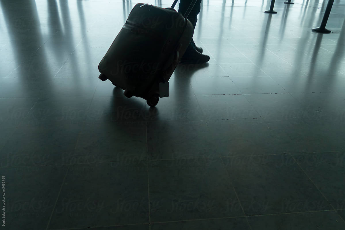 one man walking with a suitcase legs closeup