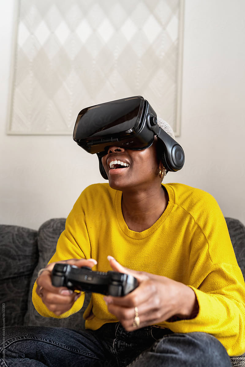 Happy African American woman playing VR videogame