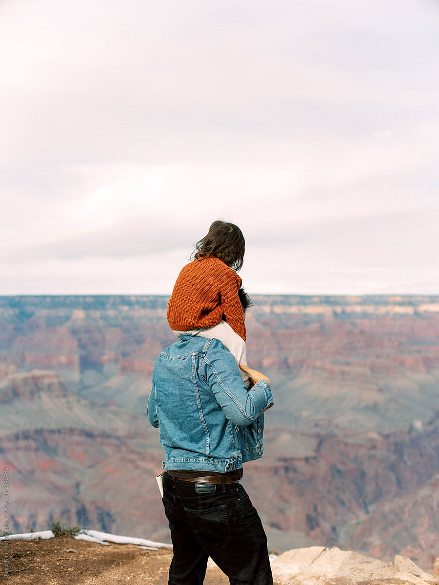 Dad holding child on shoulders at Grand Canyon