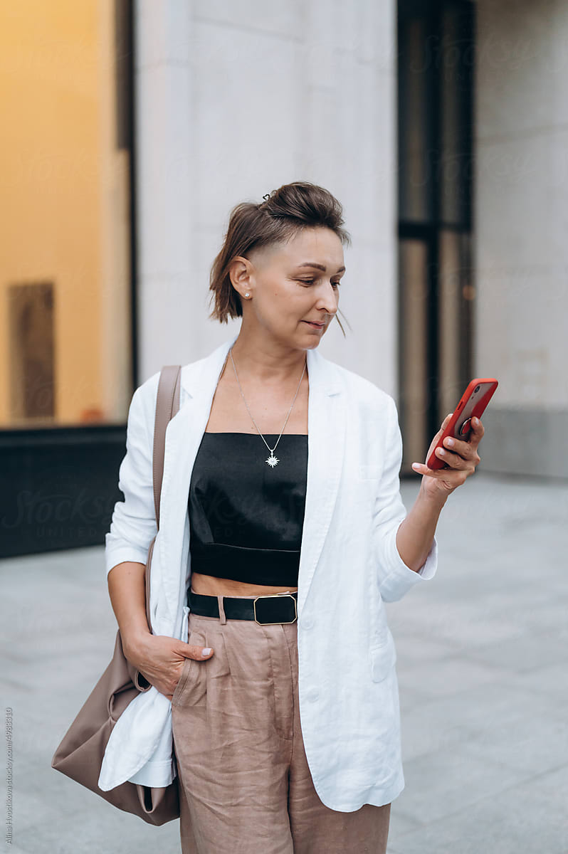 Stylish female using cellphone on street