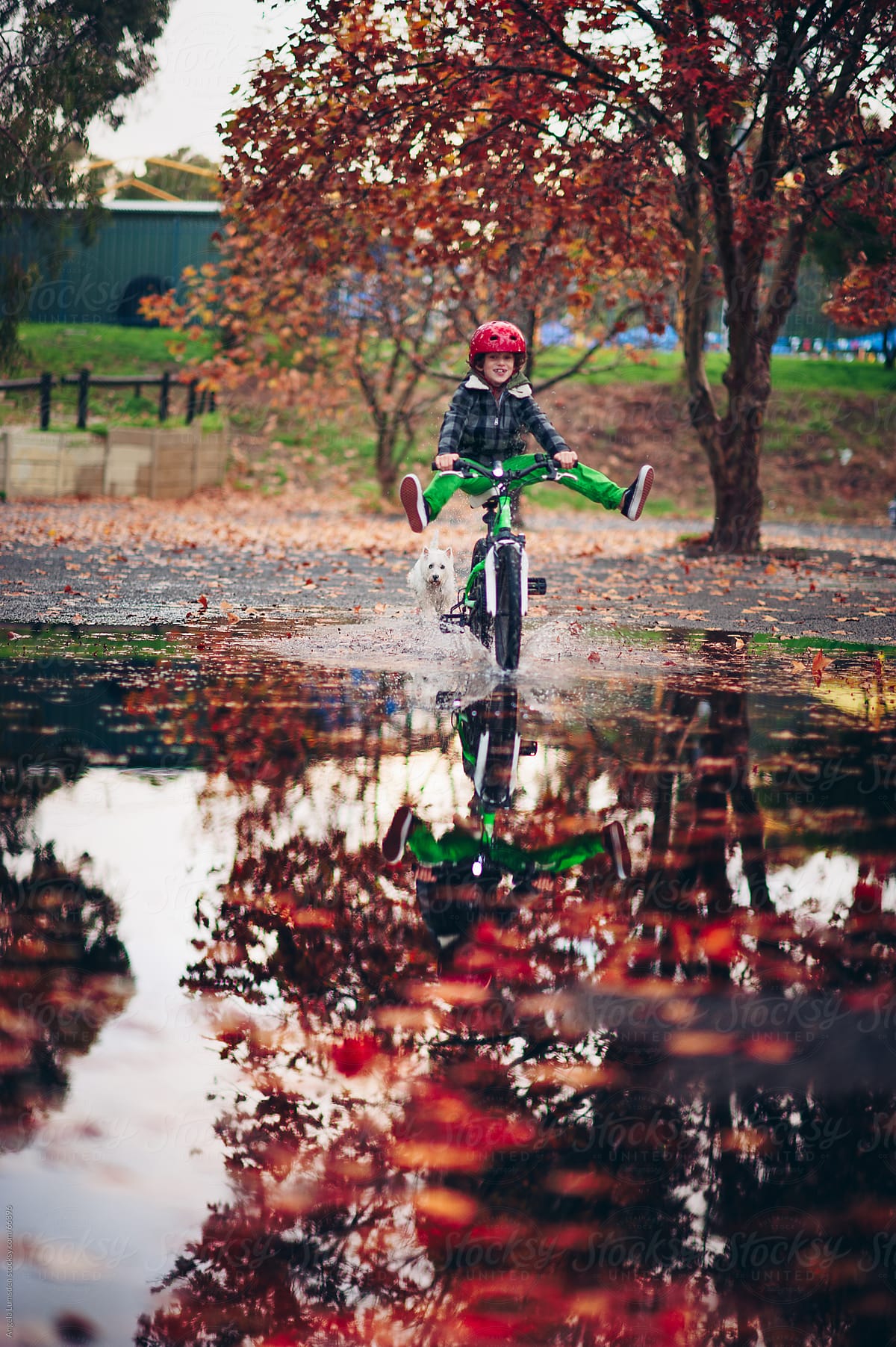 Boy riding a bike in a large puddle