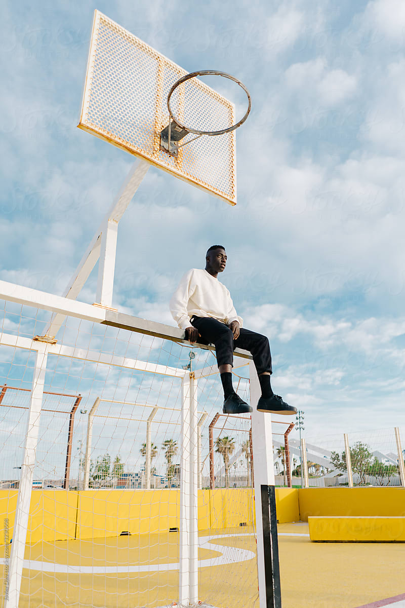 Black man sitting on basketball court