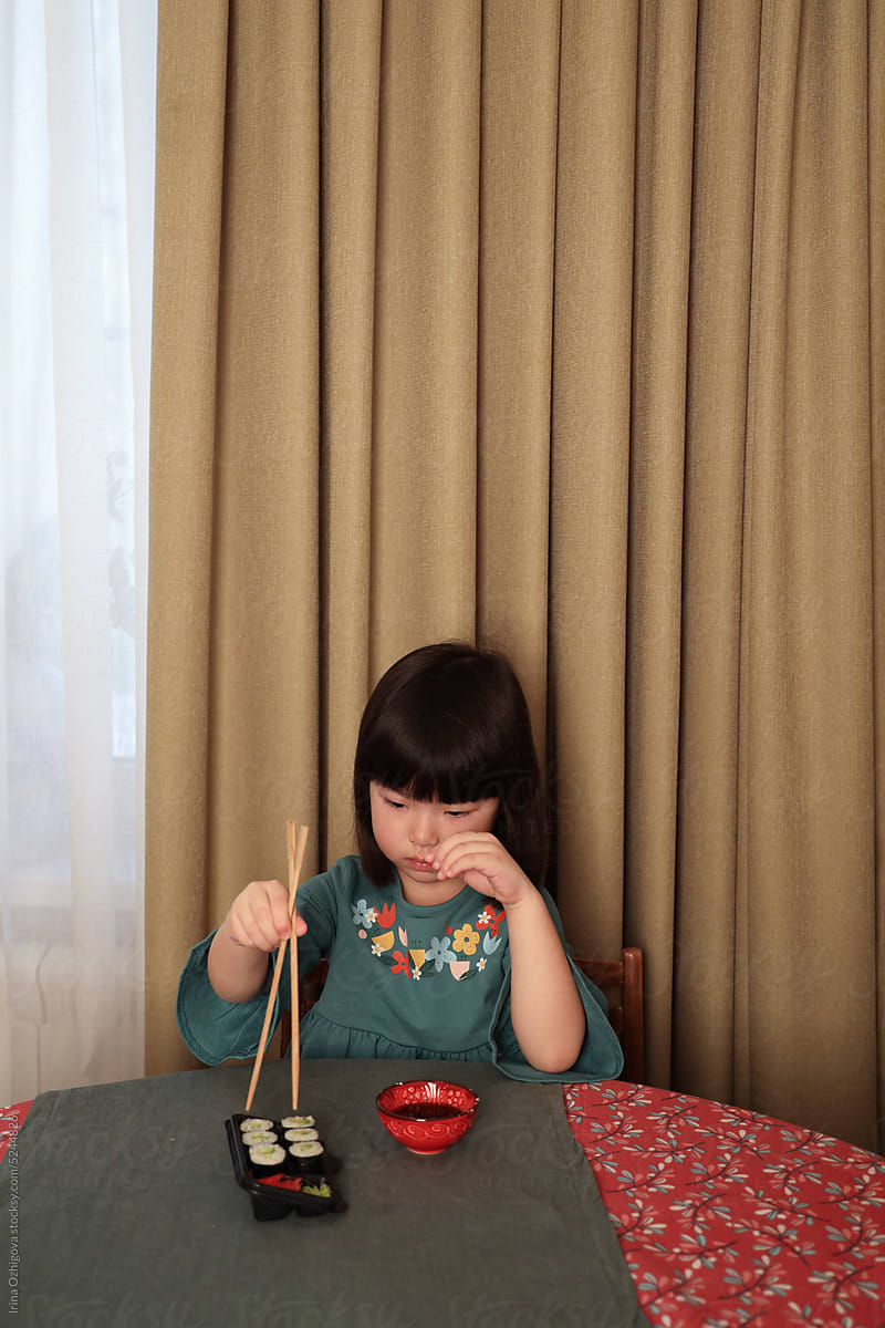 little girl eating rolls at home