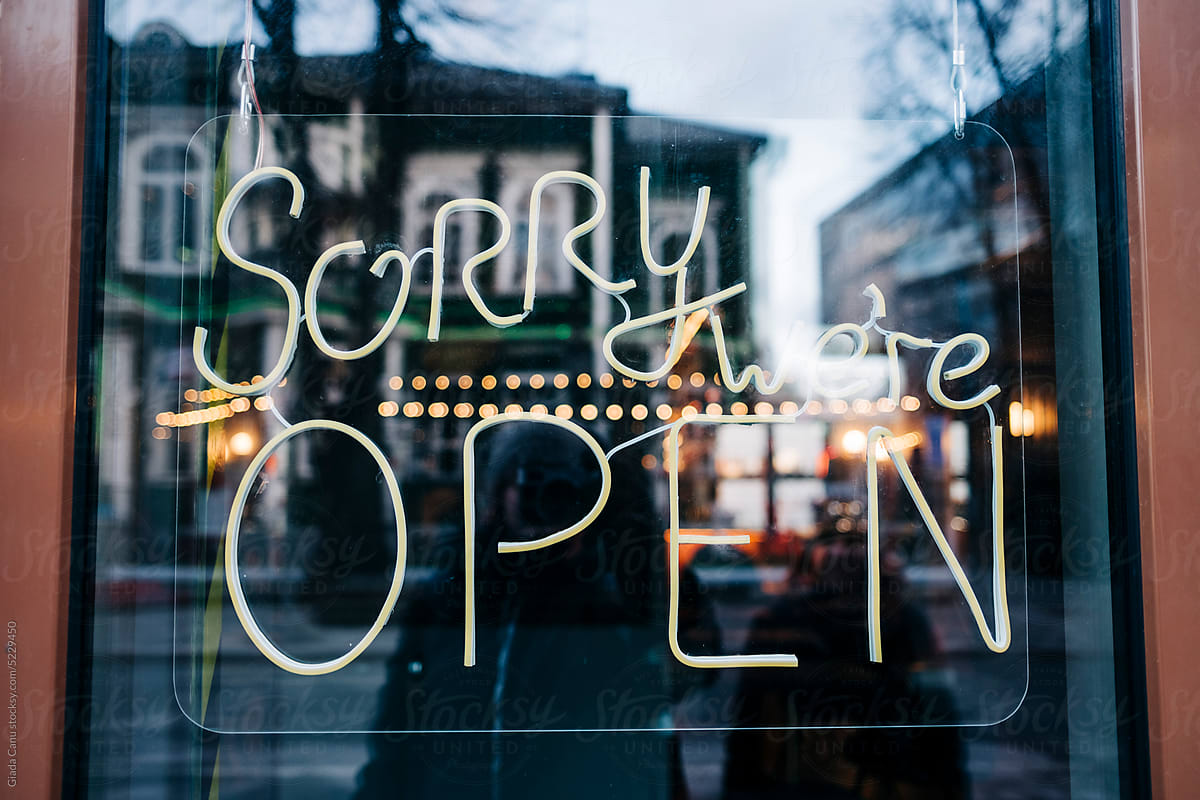 Sorry, we\'re open. Neon sign outside of a cafè