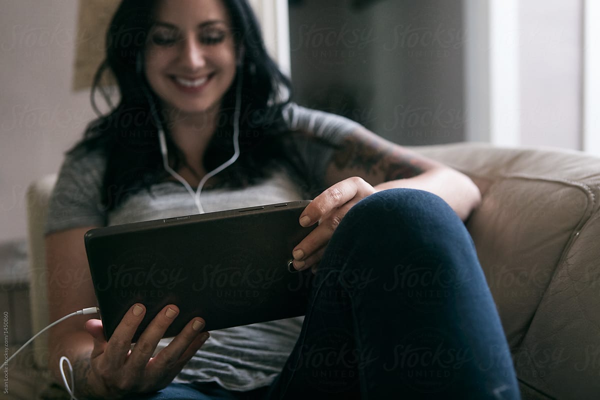Tunes: Woman Relaxes On Couch Listening To Music