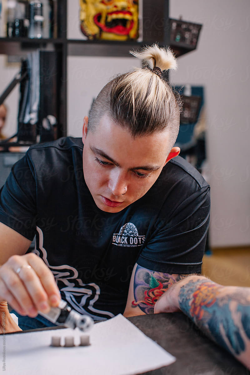 Young stylish man prepare colors for future tattoo