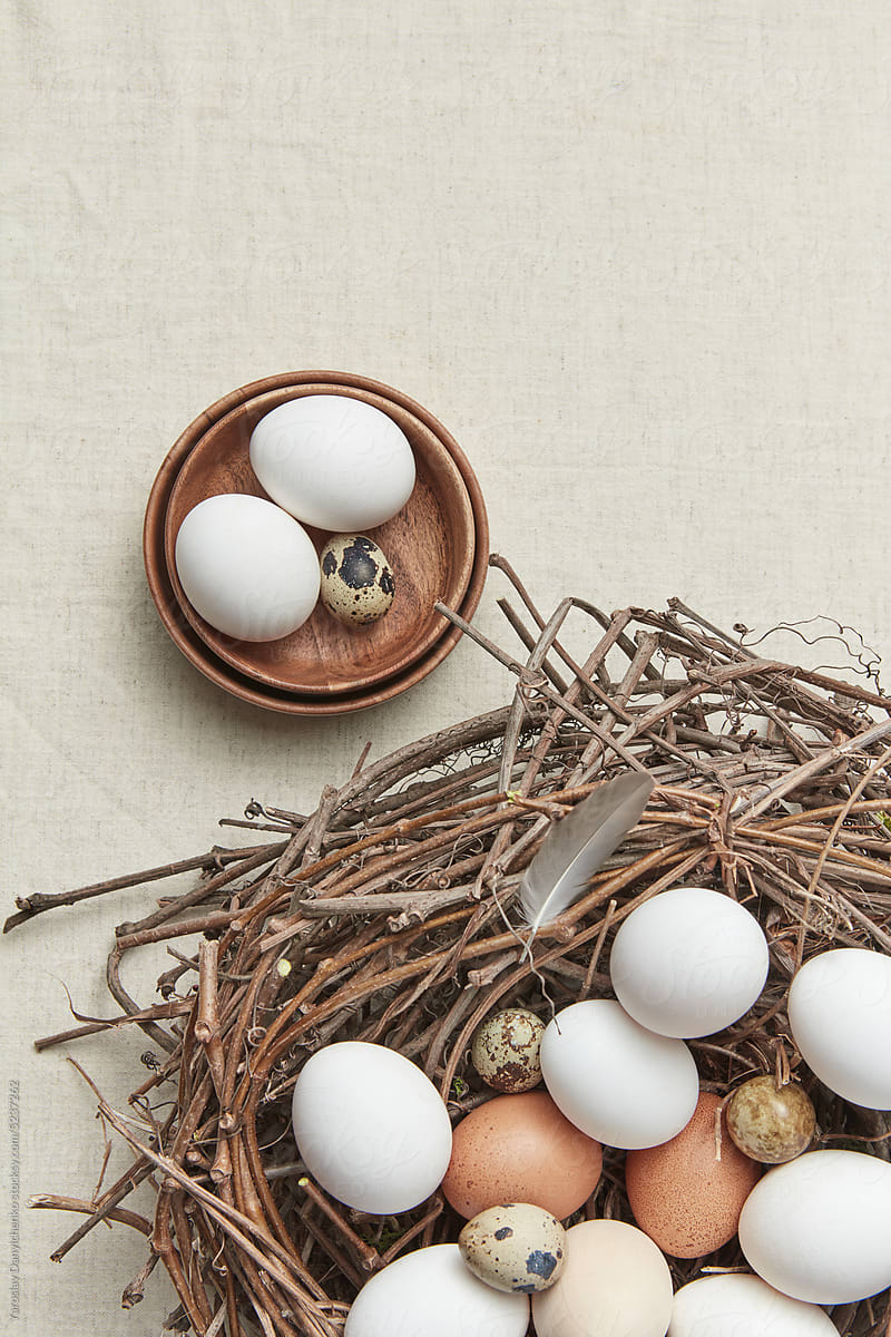 Chicken and quail eggs in bowls and nest.