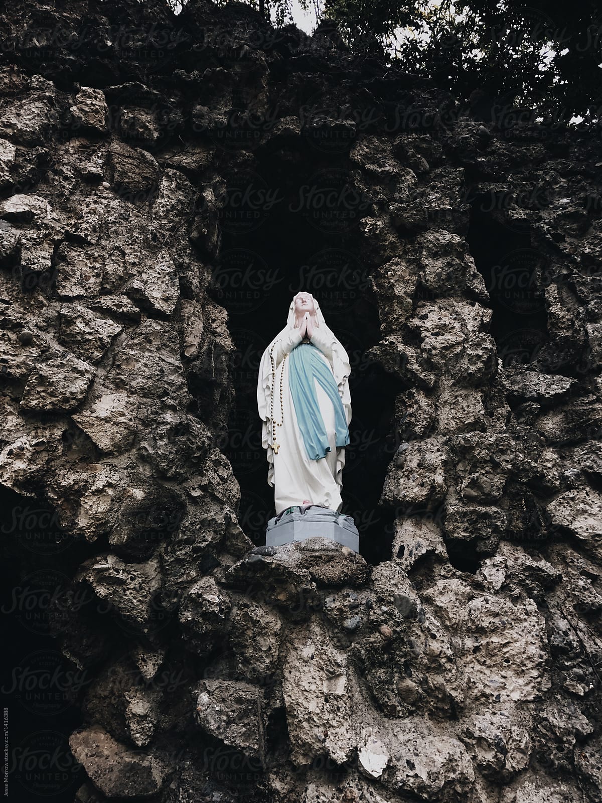 mother mary catholic christian symbolism statue in rock on hillside