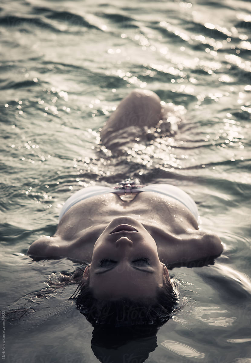 Beautiful young woman floating in the water