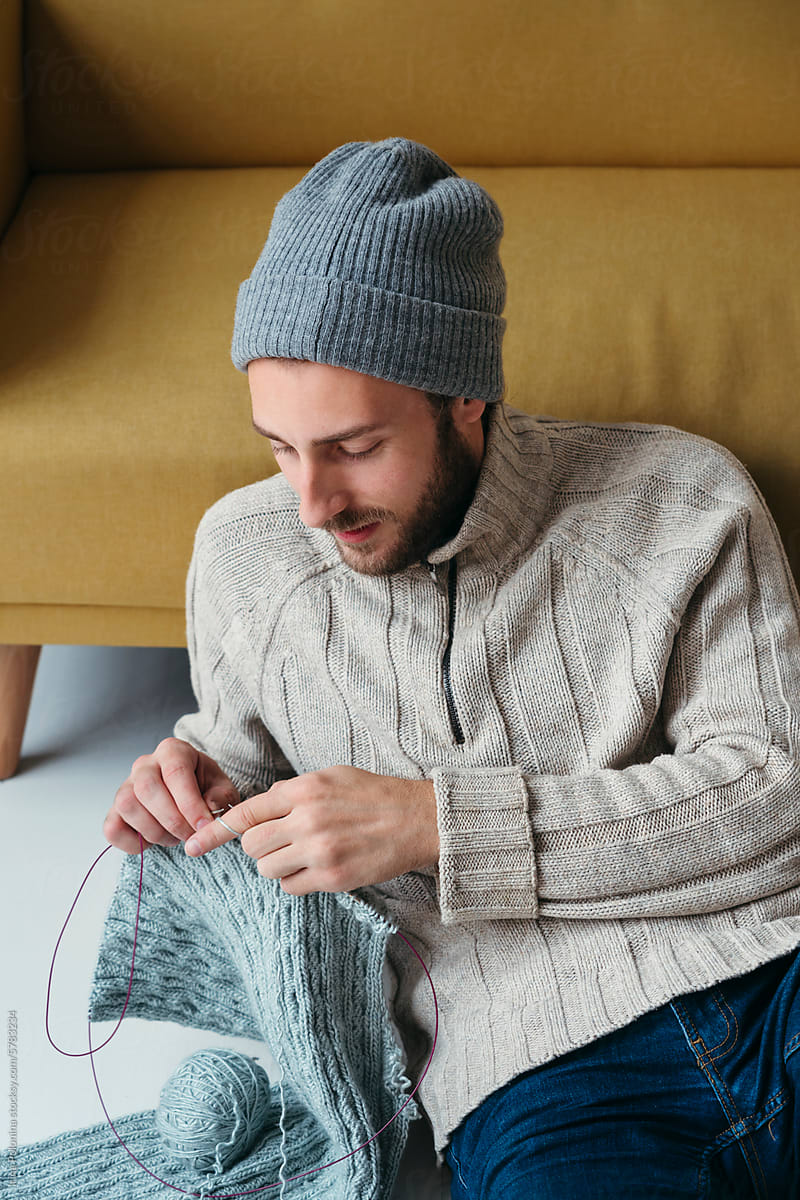 Male knits sweater.