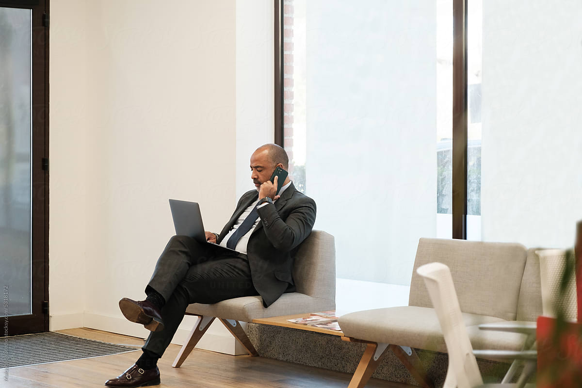 Businessman in a phone call using laptop at office