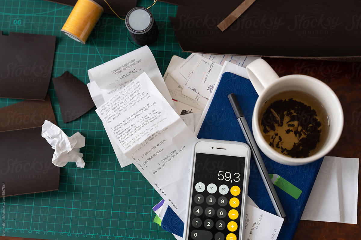 Creative workspace of leatherworker filled with receipts and tools.