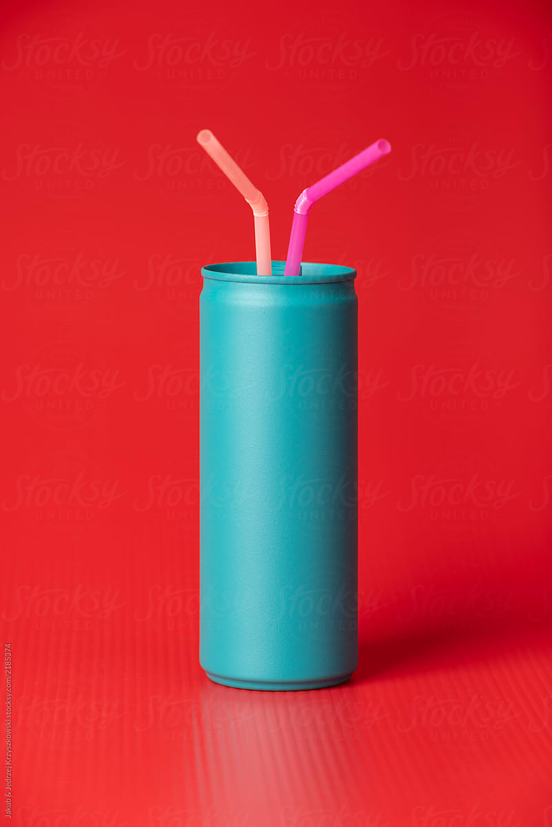 Turquoise can with pink straws on a red background.