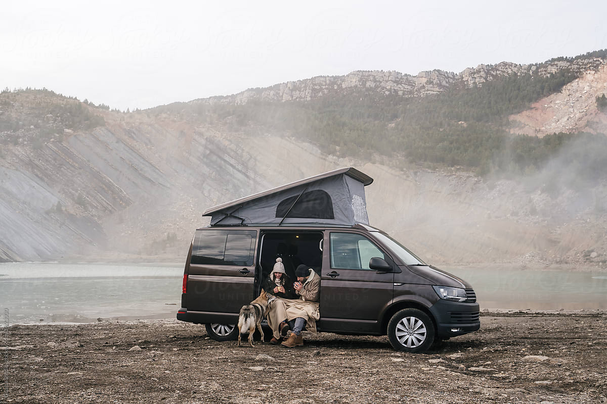 Young couple in a camper van in nature during winter
