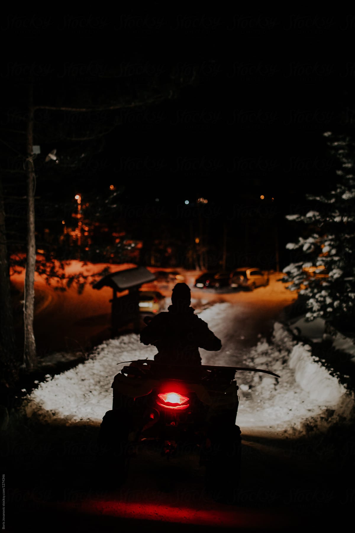 Man driving ATV on a road covered with snow