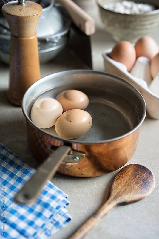 Boiled eggs in a pan on a table.