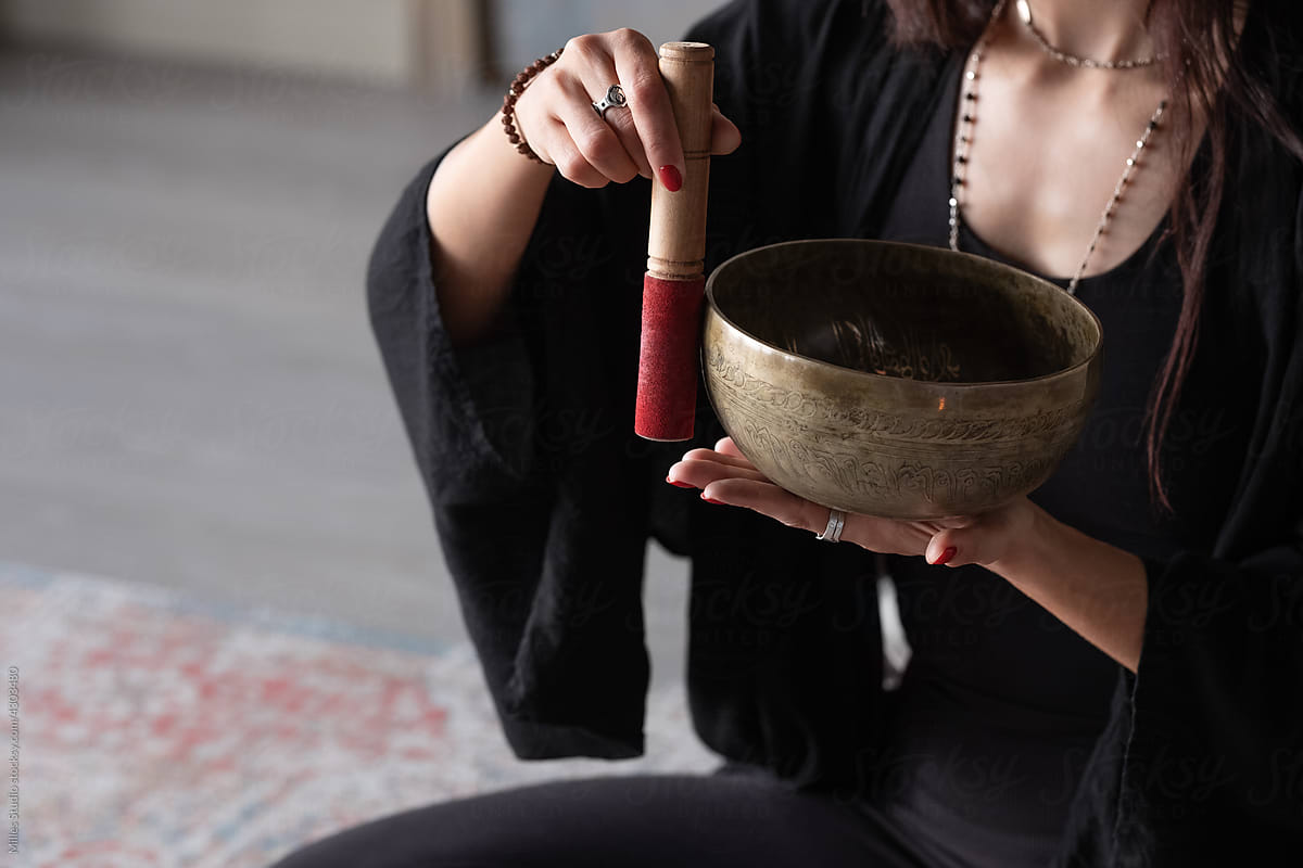 Anonymous woman meditating with singing bowl