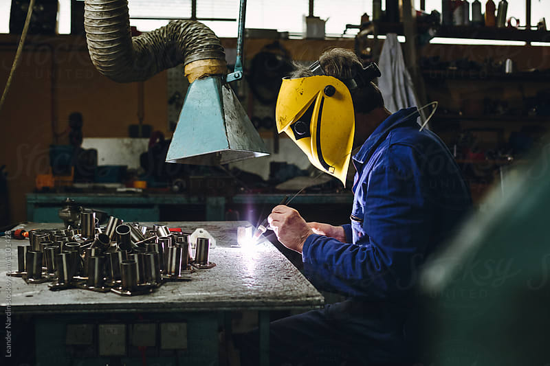 portrait of a welding metal worker wearing yellow protection mask