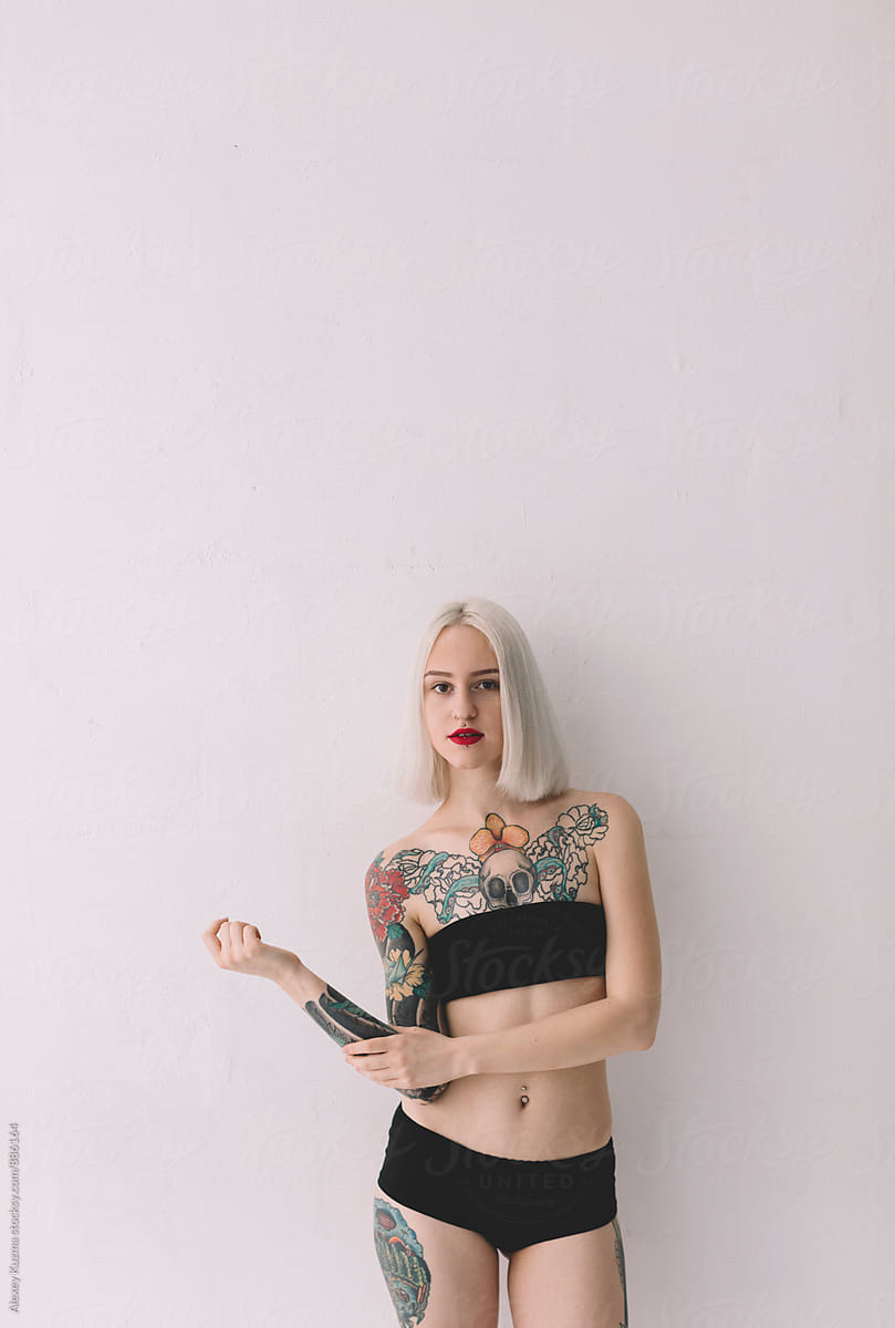 blond woman with tattoos on the white background