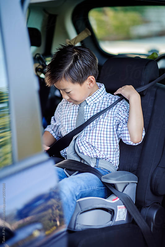 Back to school: Asian boy wearing a seat belt in a car