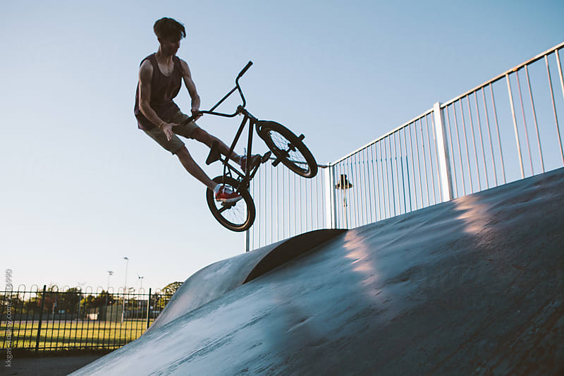 BMX rider performing stunts and tricks on ramps in a skate park