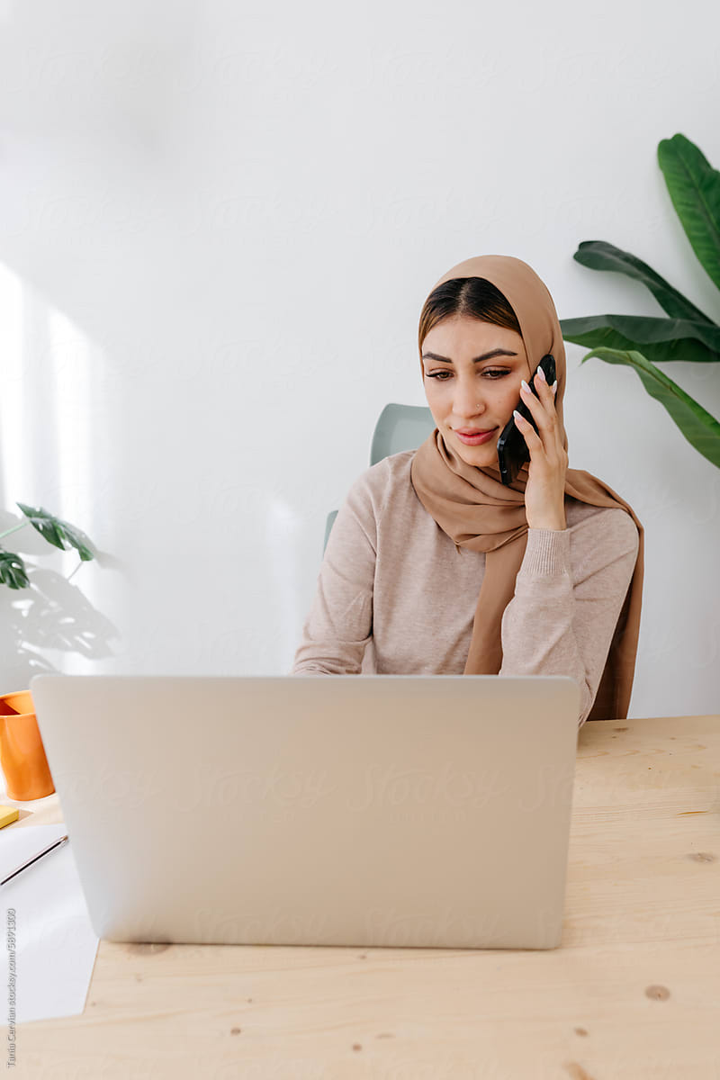 Focused woman in hijab speaking on smartphone