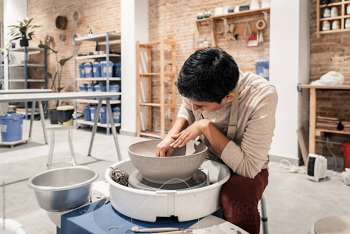 Ceramist woman making clay bowl with pottery