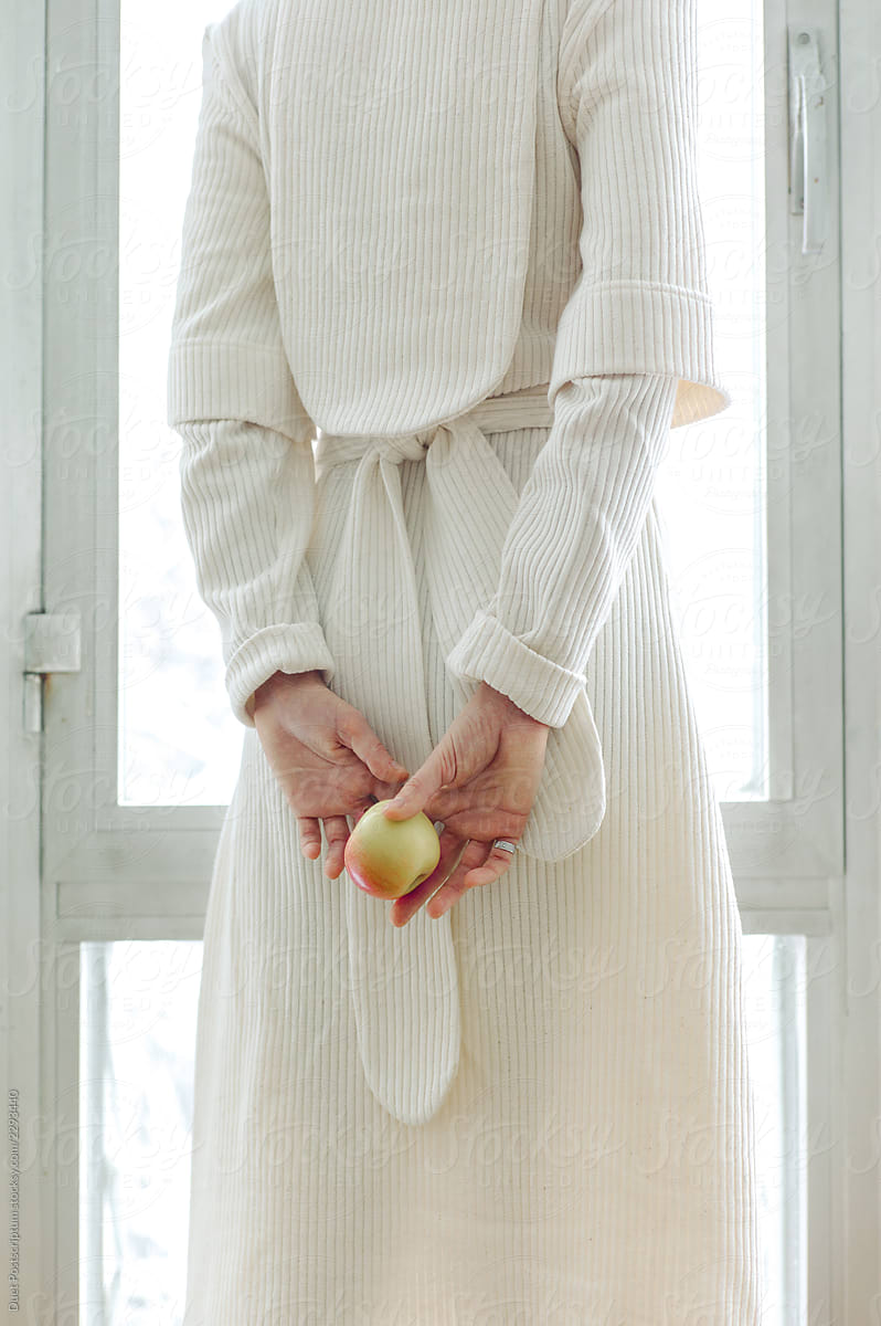Crop woman in white dress holding apple