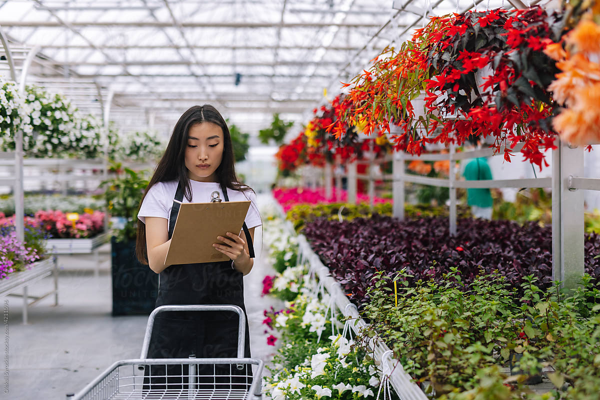 Female garden worker making notes to control list