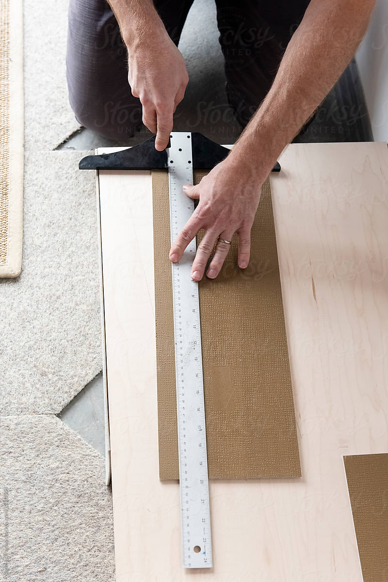 Man cutting material with T-square ruler