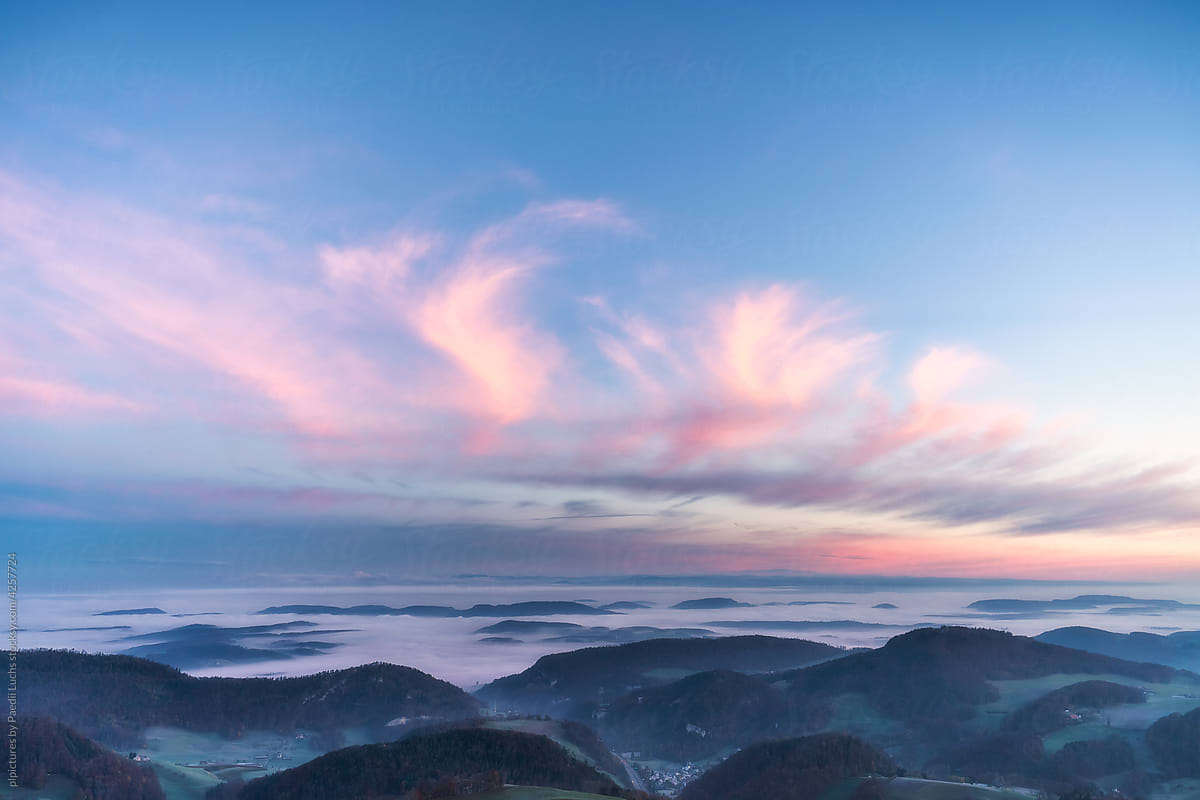 Colorful sky over rolling hills.