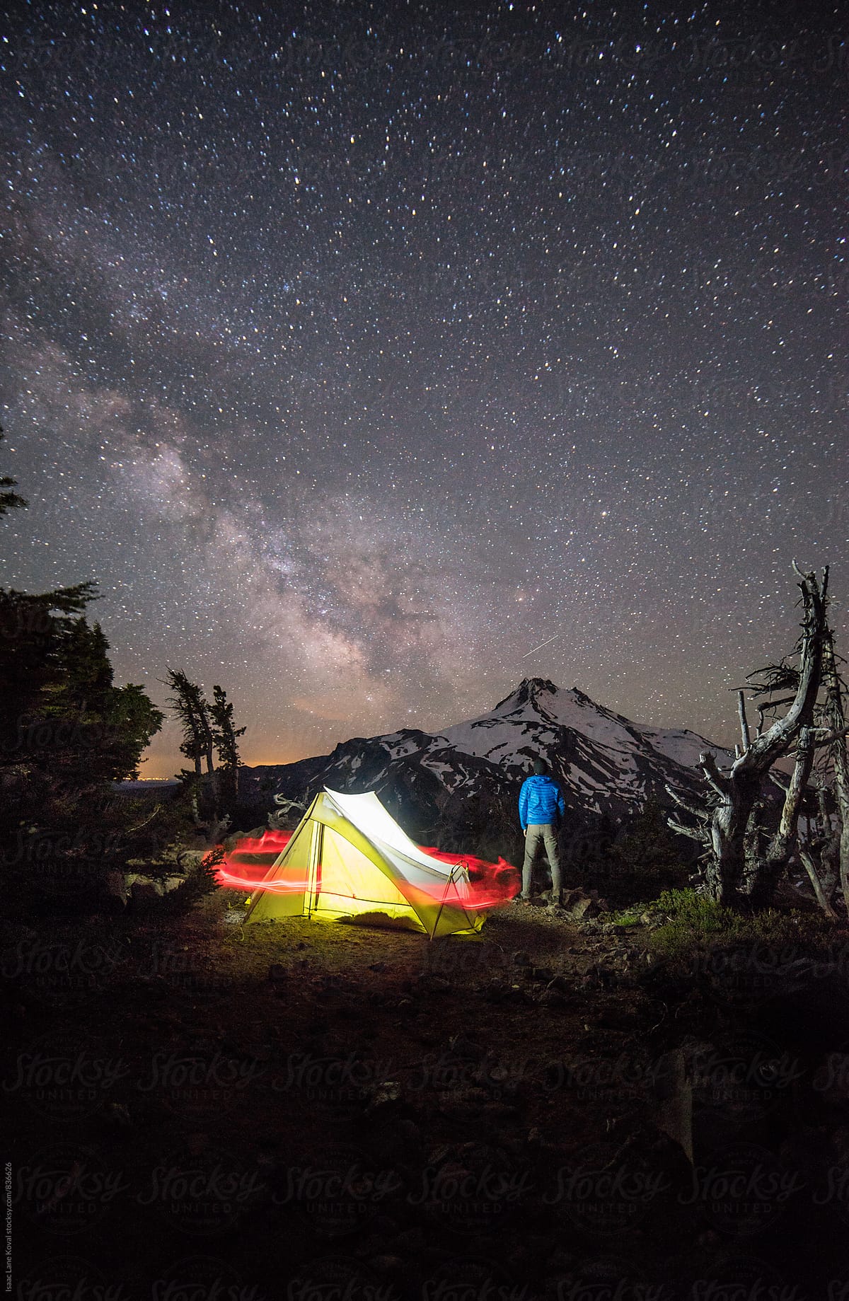 Man standing watch in front of Mt Jefferson with starry night sky