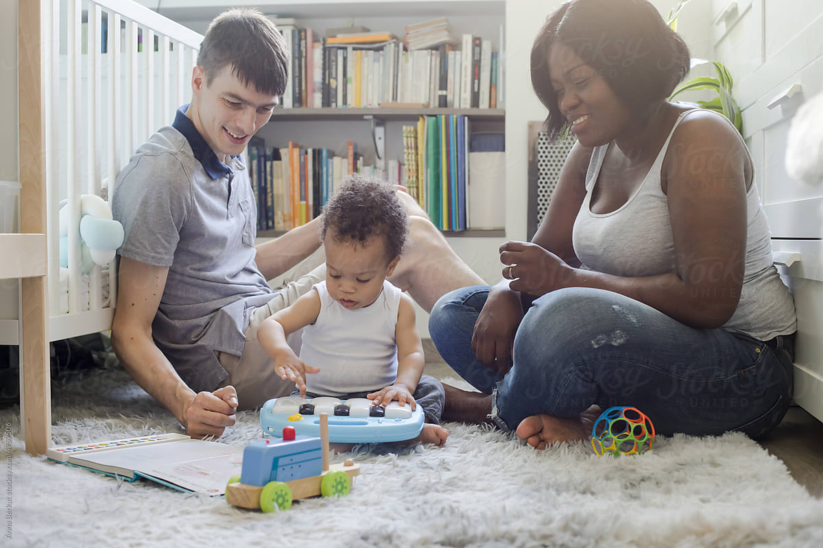 parents with toddler baby child playing with toys at home, toy piano