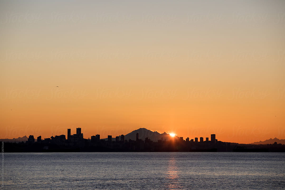 The sun rising behind Vancouver and Mount Baker