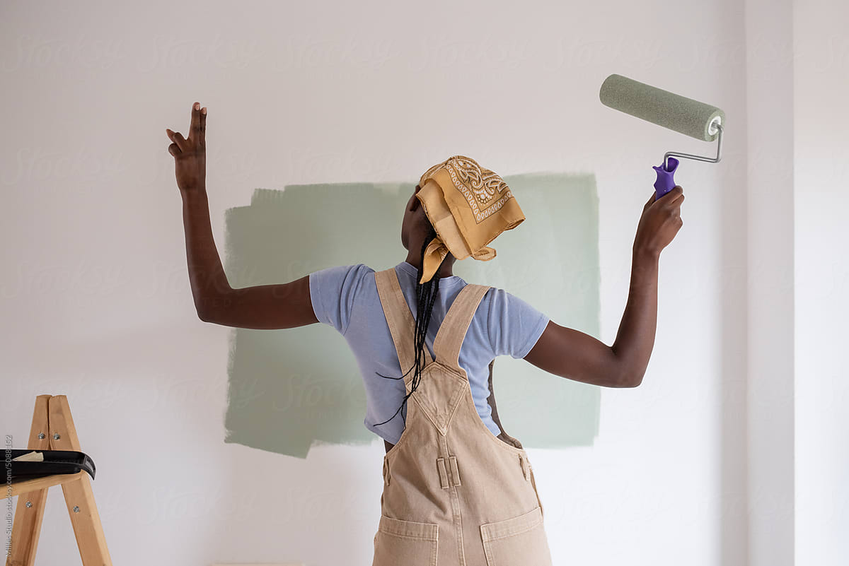 Black female painter pointing up and dancing