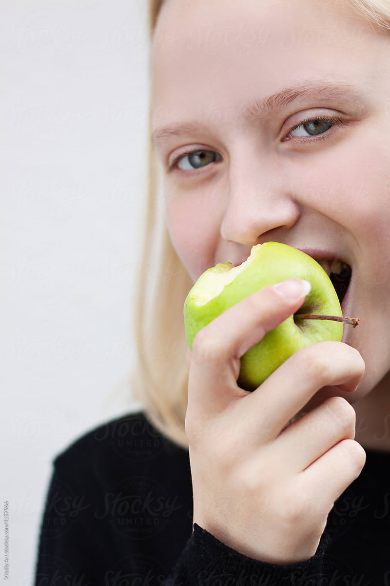 Young woman bites an apple