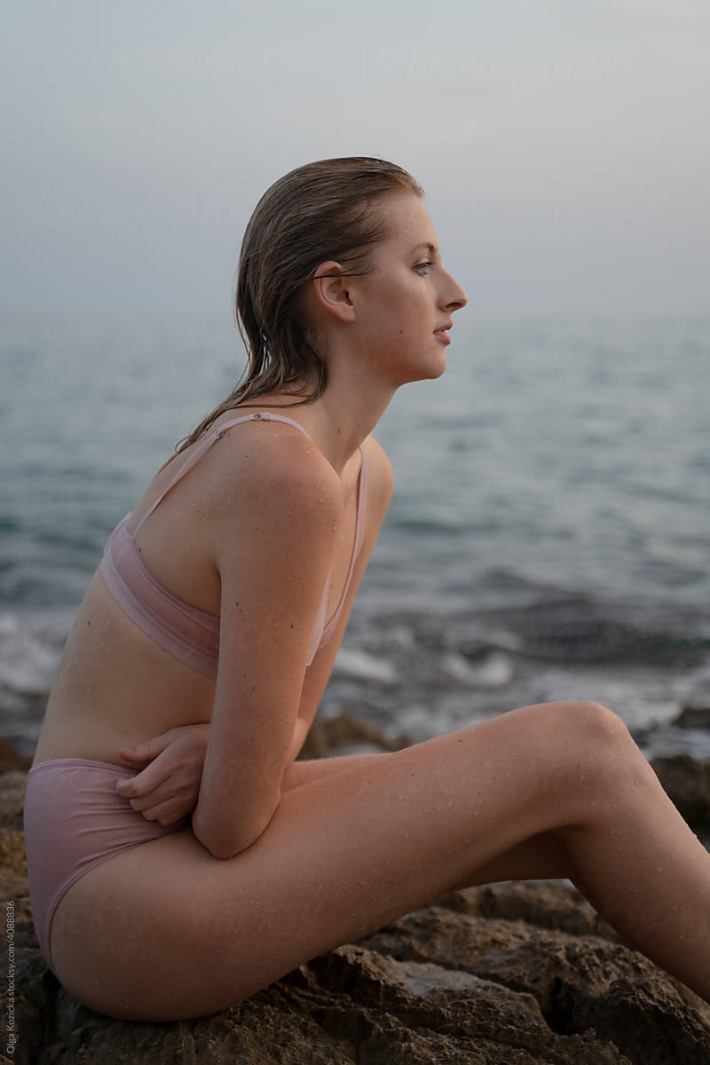 Wet Woman In Underwear Sitting By The Sea by Stocksy Contributor