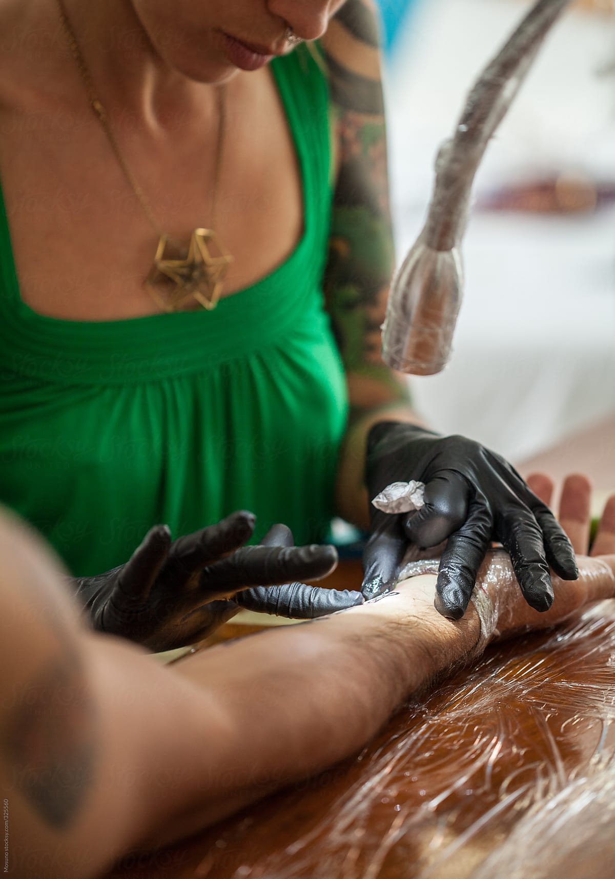 Tattoo Artist Applying Cream on Man's Arm