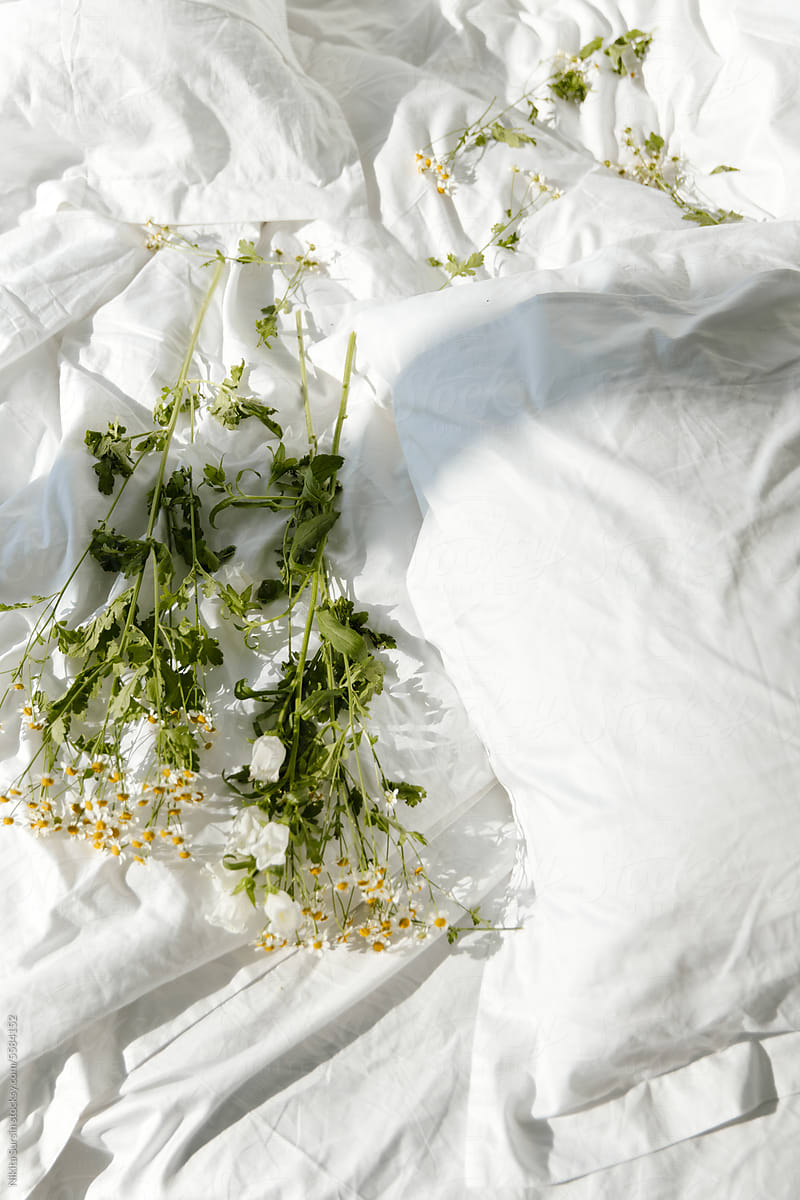 white flowers lie on a white blanket