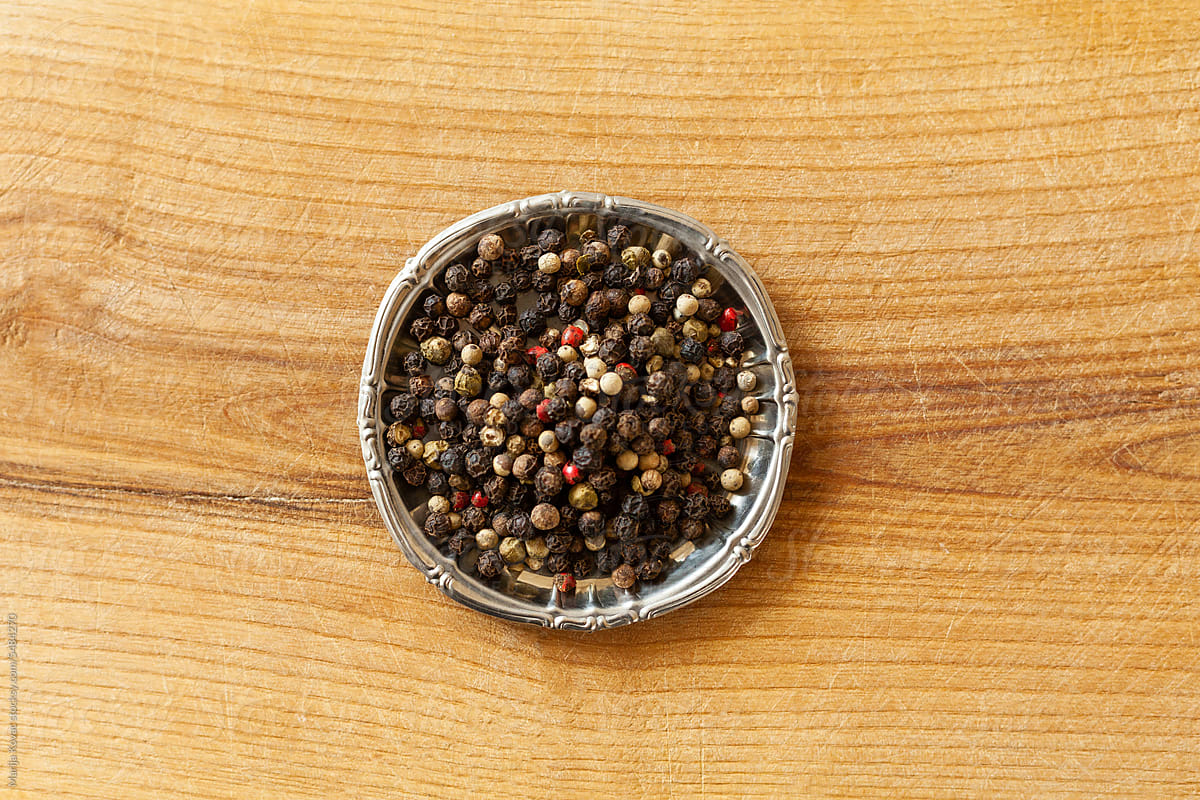 Before and after shot of peppercorns and ground pepper