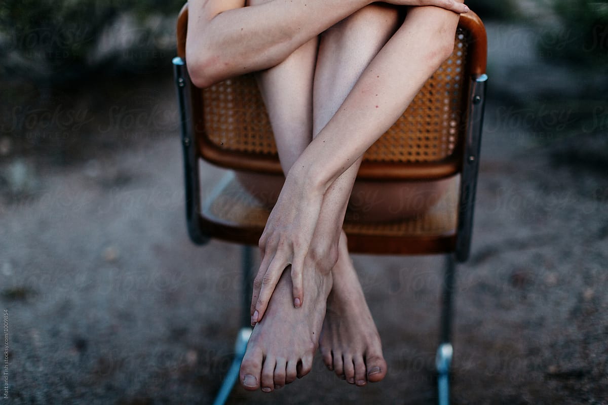 Legs and arms hanging over chair