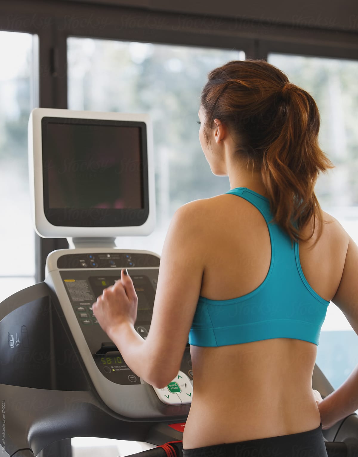 Woman working out in hotel gym on treadmill