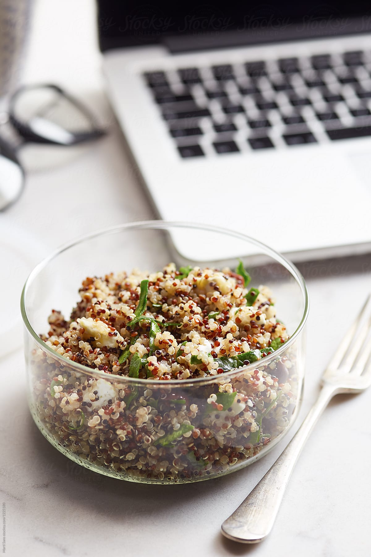 Quinoa salad with goat cheese and olive on office desk