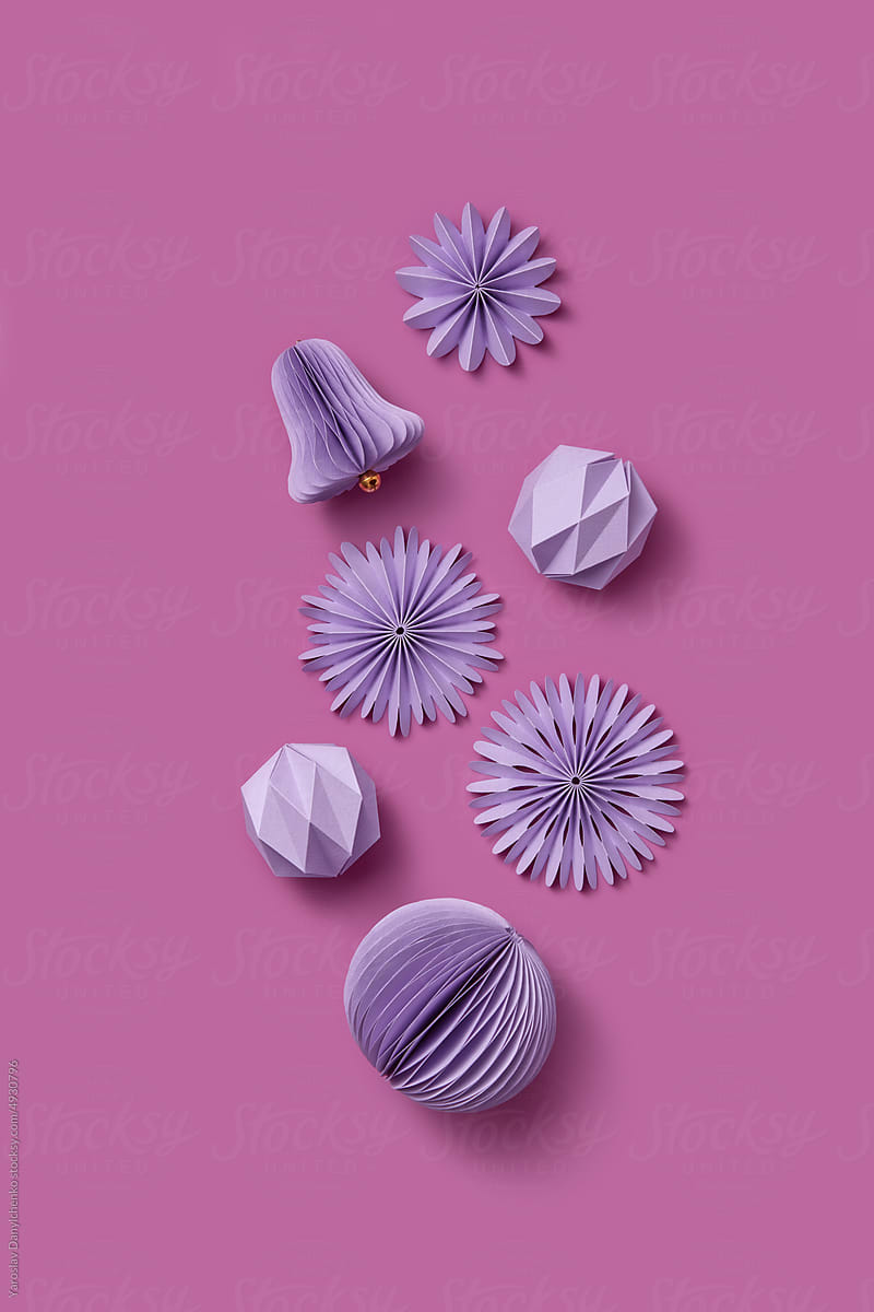 Paper Christmas ornaments on pink background.