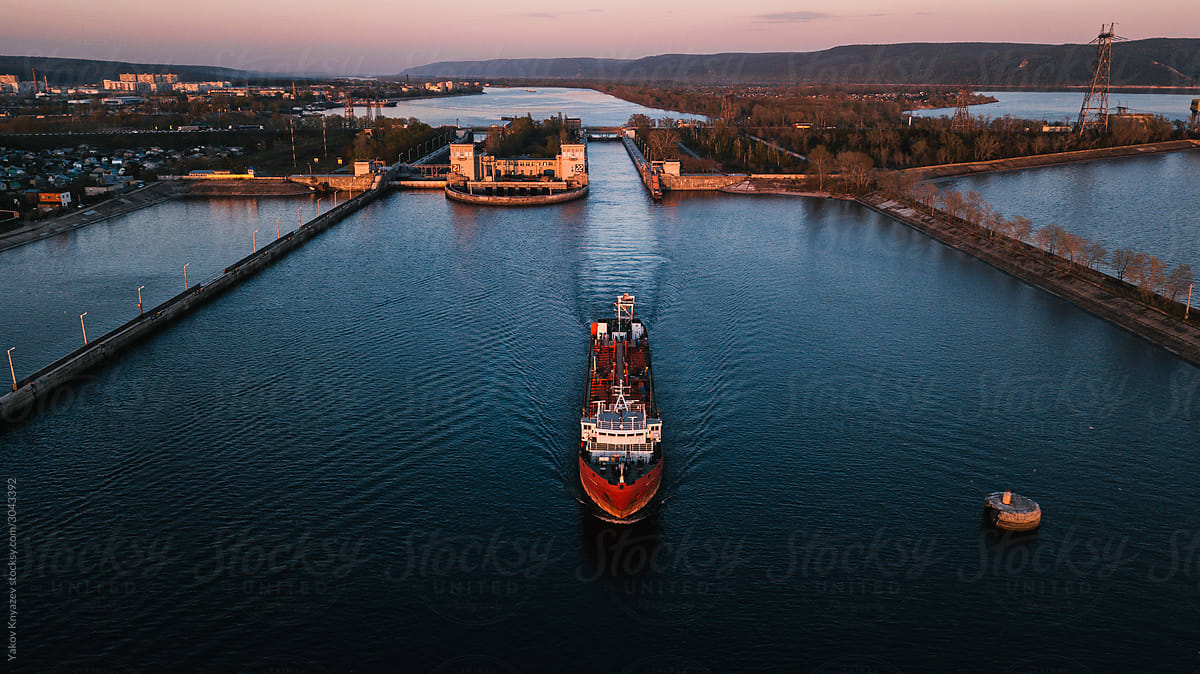 Top-view of a barge ship passing by the gateway